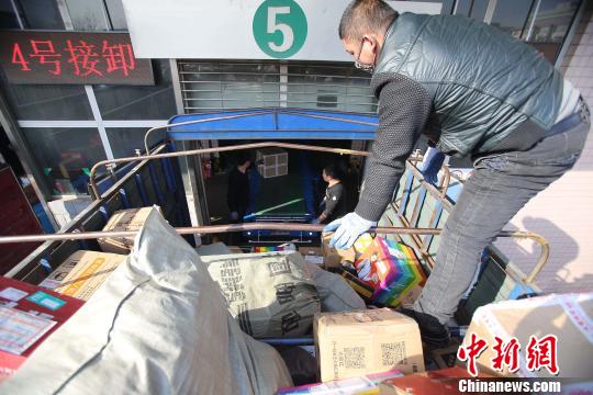資料圖：工作人員正在給快遞包裹裝車。張?jiān)啤z